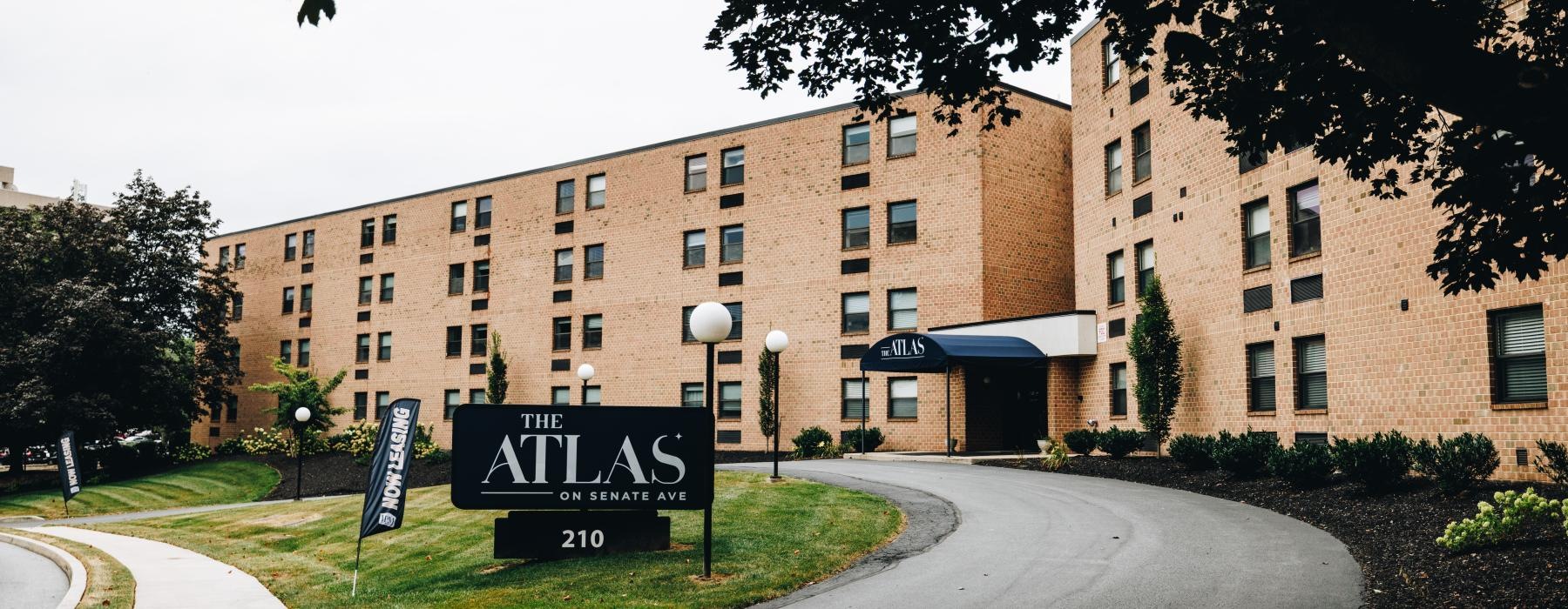 a building with a sign out from that reads the atlas