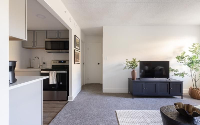 a kitchen with white cabinets and a living room