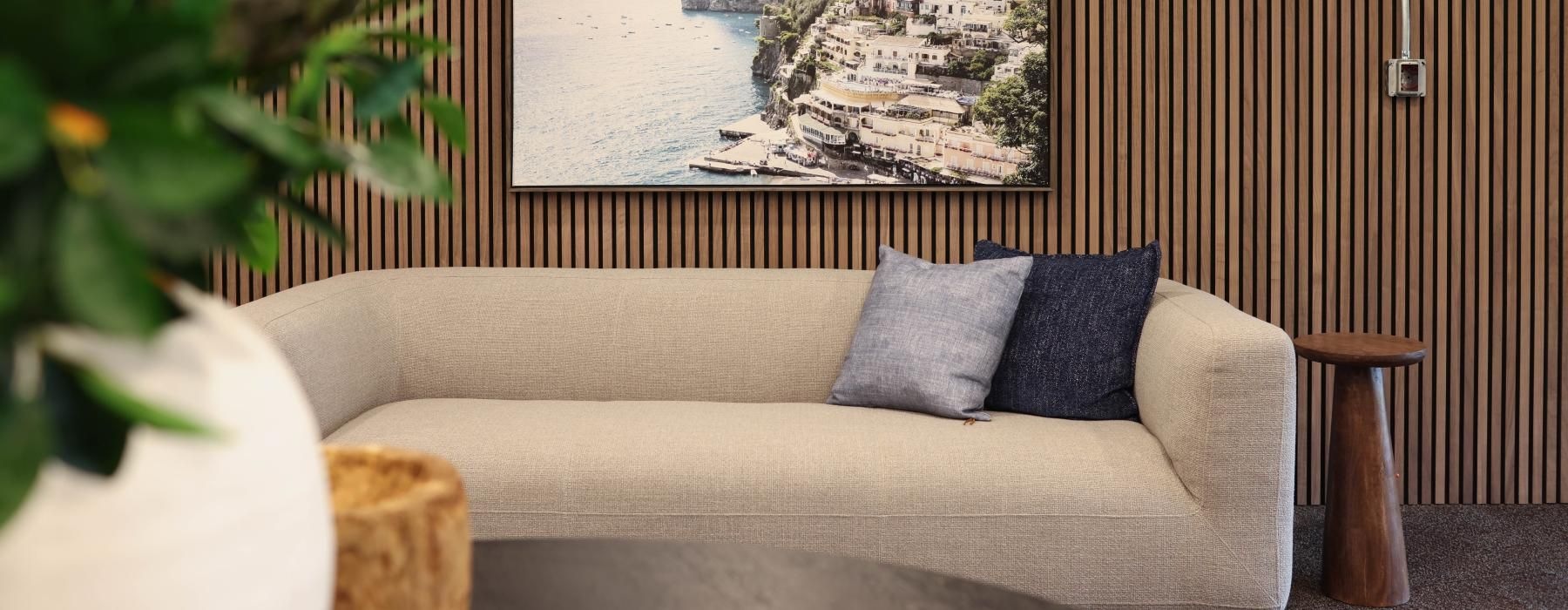 a couch with pillows and a painting on the wall